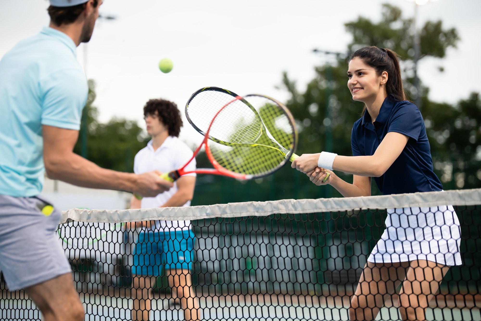 Fit happy poeple playing tennis together. Sport concept